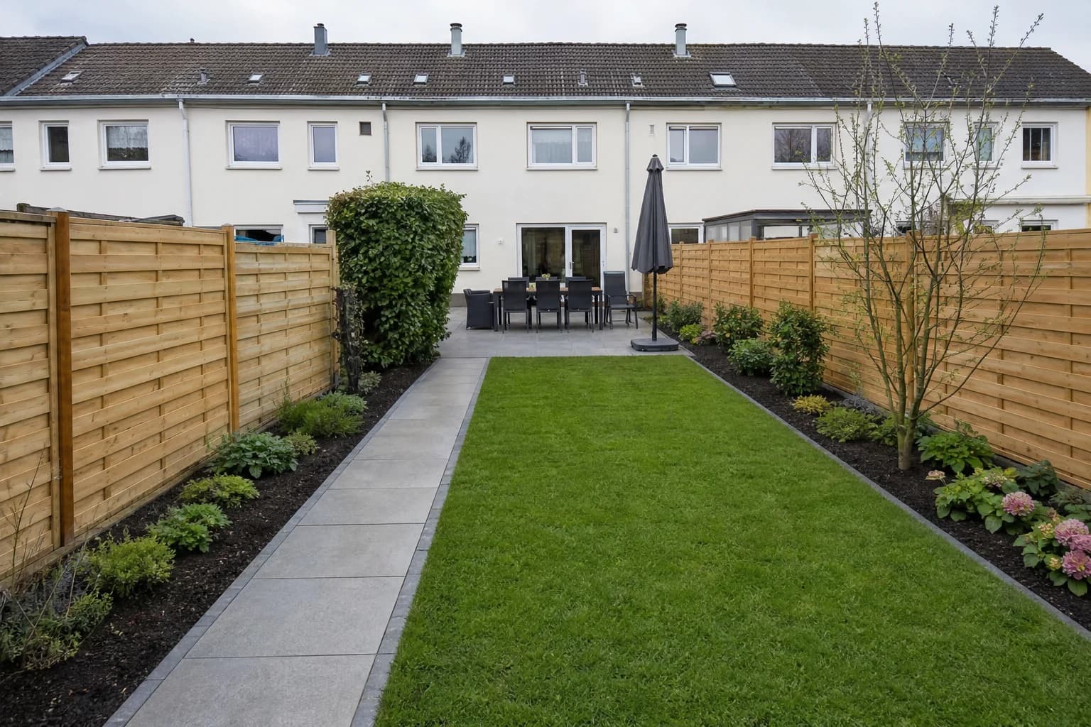 Umgestalteter Reihenhausgarten mit Rollrasen, Weg und Terrasse