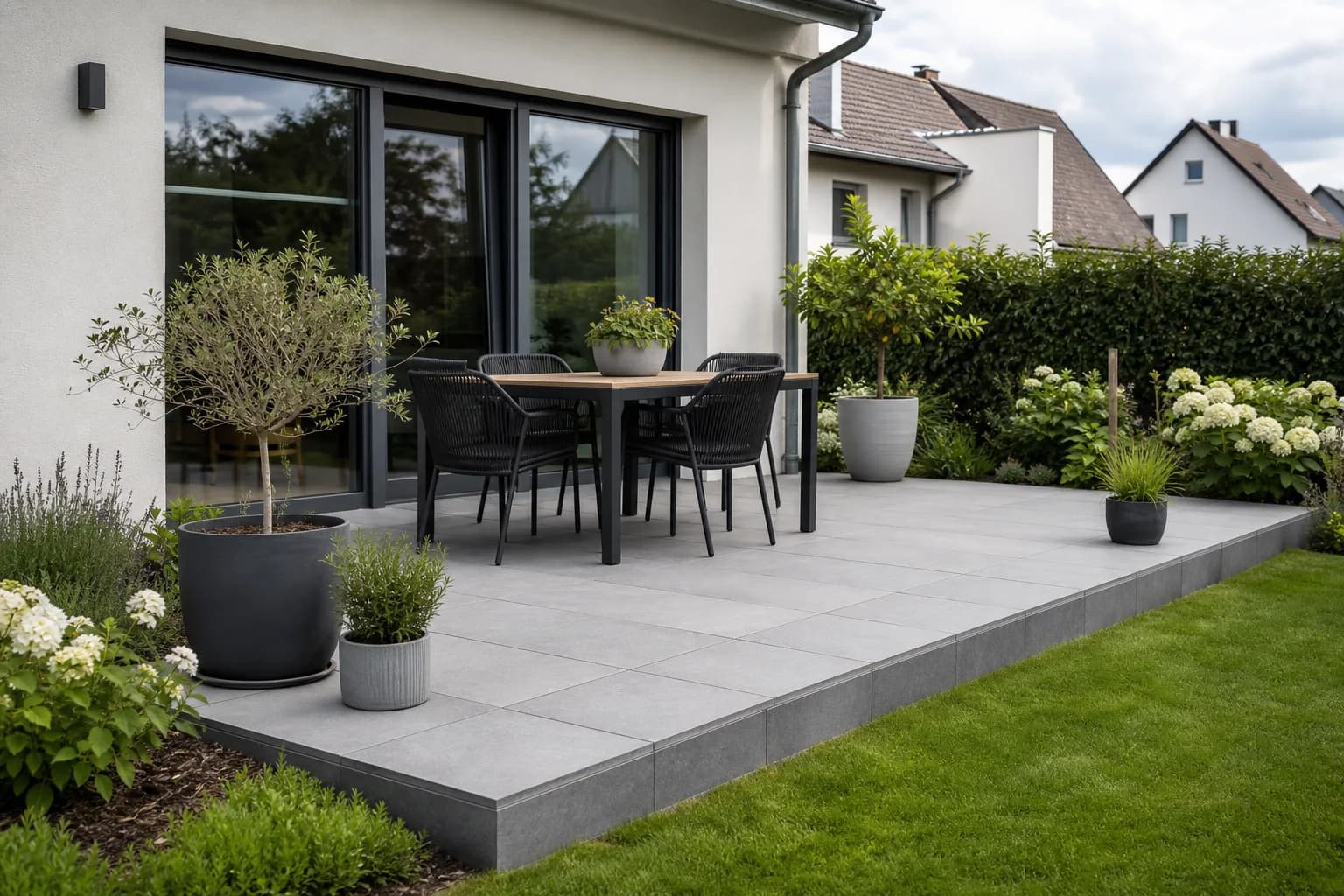 Neu gebaute Terrasse mit großformatigen Platten und Gartenanschluss